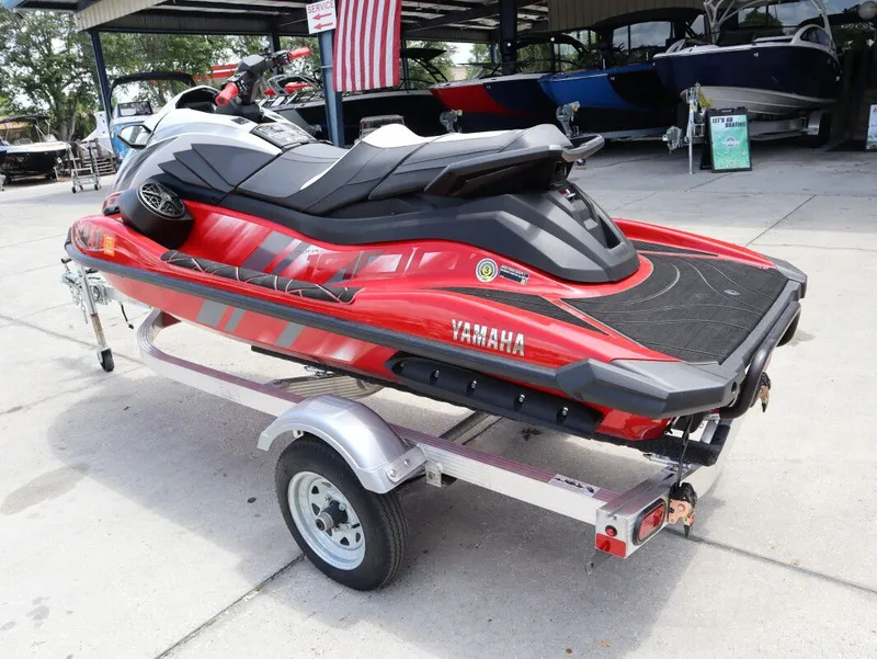 Slide: The Image of 2025 Yamaha GP 1900 HO jet ski on trailer, red and black, outdoors. - 9