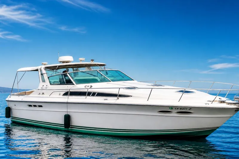 The Image of 1987 Sea Ray 390 Express yacht on calm blue water under clear sky. - 0