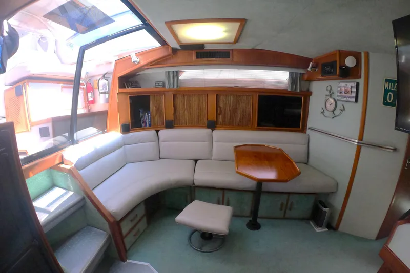 Slide: The Image of Interior of 1987 Sea Ray 390 Express with cozy seating and wooden table. - 11