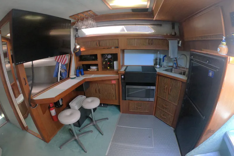 Slide: The Image of Interior of a 1987 Sea Ray 390 Express yacht with galley and seating area. - 12