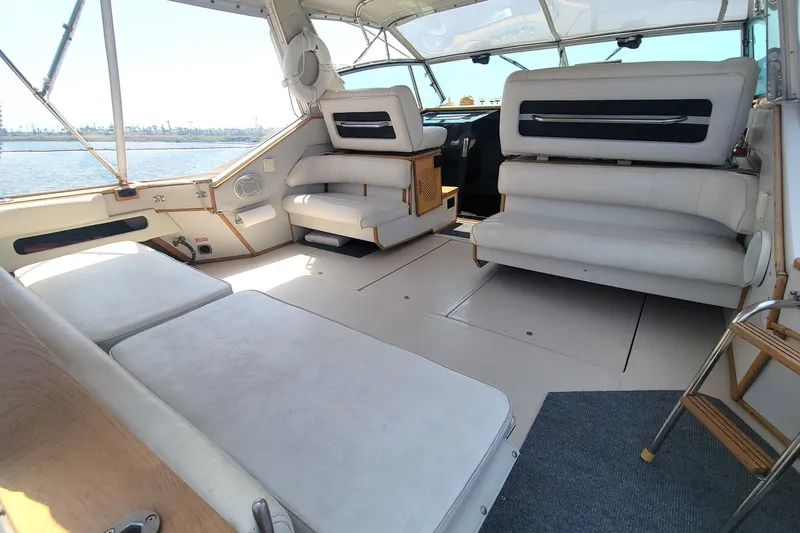 Slide: The Image of 1987 Sea Ray 390 Express docked, reflecting sunlight on calm water. - 3