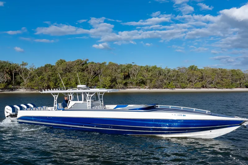 Slide: The Image of 2018 Hann 53 boat cruising on a sunny day near a forested shoreline. - 28