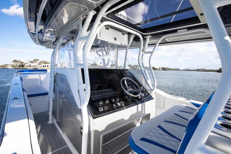 Slide: The Image of 2018 Hann 53 boat interior with modern helm and blue seating on a sunny day. - 7