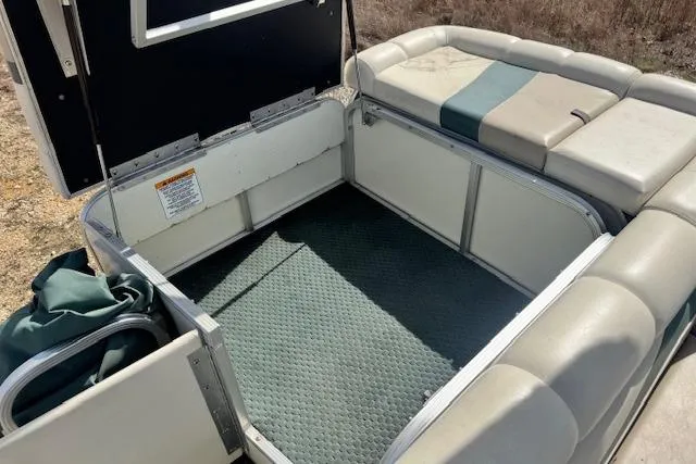 Slide: The Image of Open storage compartment on 2002 Bennington 2575RL I/O boat with cushioned seating. - 12