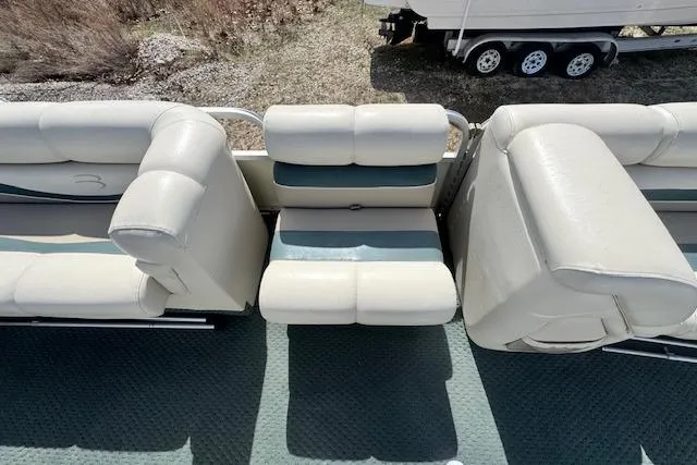 Slide: The Image of 2002 Bennington 2575RL I/O boat interior with beige seating and green carpet. - 22