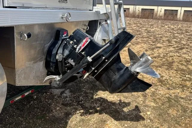 Slide: The Image of Outboard motor of a 2002 Bennington 2575RL I/O boat on dry land. - 24