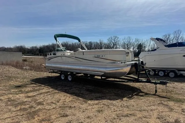 Slide: The Image of 2002 Bennington 2575RL I/O pontoon boat on trailer in outdoor setting. - 6