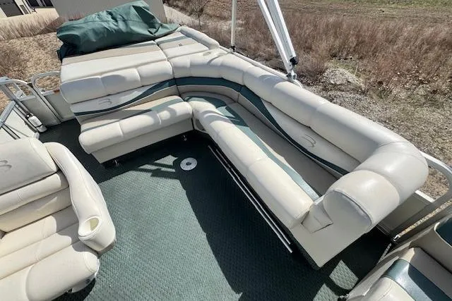 Slide: The Image of 2002 Bennington 2575RL I/O boat with spacious, cushioned seating and green carpet flooring. - 7