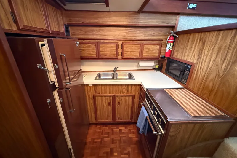 Slide: The Image of 1979 Viking 43 Double Cabin kitchen with wood cabinetry, stove, and sink. - 12