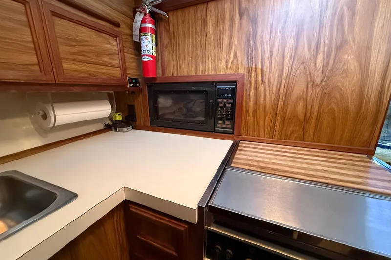 Slide: The Image of 1979 Viking 43 Double Cabin kitchen with wood paneling, microwave, and countertop. - 13