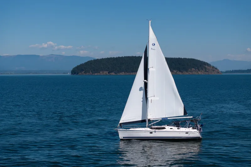 The Image of Sailing yacht Hunter 45 Deck Salon 2008 on serene blue waters with island backdrop. - 1
