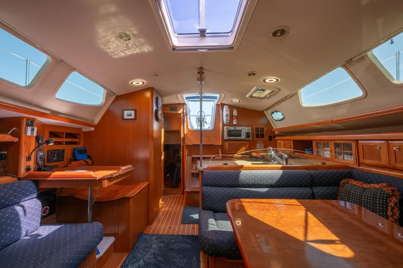 Slide: The Image of Interior of 2008 Hunter 45 Deck Salon yacht with wood finish and seating area. - 16
