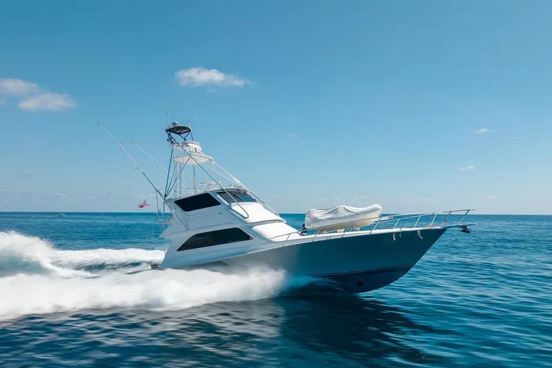 Slide: The Image of 2005 Viking 61 Enclosed Bridge yacht cruising on open sea under clear blue sky. - 11