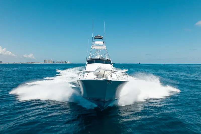 Slide: The Image of 2005 Viking 61 Enclosed Bridge yacht cruising on open ocean under clear blue sky. - 13