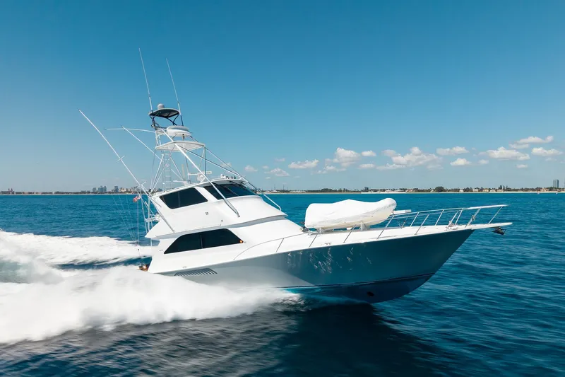 Slide: The Image of 2005 Viking 61 Enclosed Bridge yacht cruising on open water under clear skies. - 20