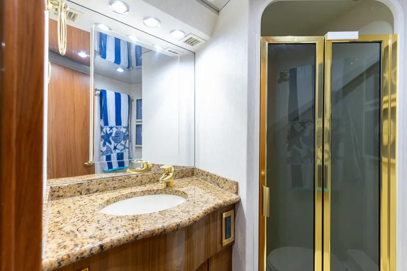 Slide: The Image of Luxurious bathroom in 2005 Viking 61 Enclosed Bridge yacht with granite countertop and glass shower. - 23