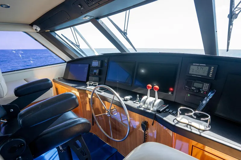 Slide: The Image of Interior view of 2005 Viking 61 Enclosed Bridge yacht helm with ocean backdrop. - 40