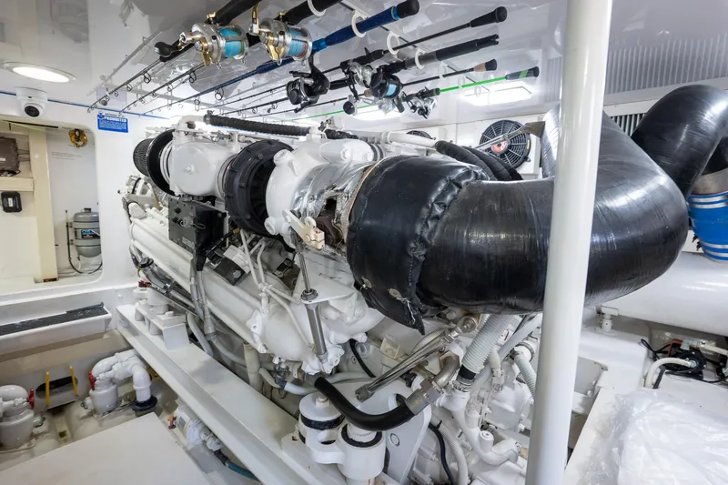 Slide: The Image of Engine room of 2005 Viking 61 Enclosed Bridge yacht, showcasing powerful machinery and fishing rods. - 46