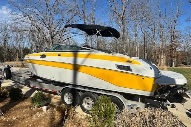 Slide: The Image of 2003 Crownline 270 BR boat on trailer, yellow and white, parked outdoors. - 10