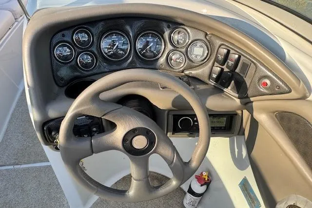Slide: The Image of Dashboard of a 2003 Crownline 270 BR boat with steering wheel and gauges. - 17