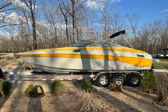 Slide: The Image of 2003 Crownline 270 BR boat on trailer, parked outdoors with trees in the background. - 5