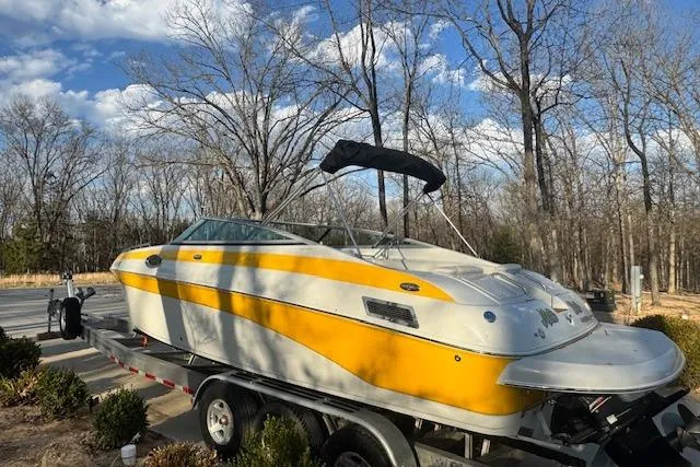 Slide: The Image of 2003 Crownline 270 BR boat on trailer, yellow and white, parked outdoors. - 6