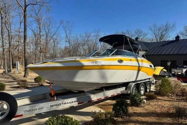 Slide: The Image of 2003 Crownline 270 BR boat on trailer, yellow and white, parked outdoors. - 8