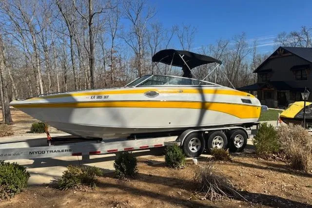 Slide: The Image of 2003 Crownline 270 BR boat on trailer, yellow and white, parked outdoors. - 9