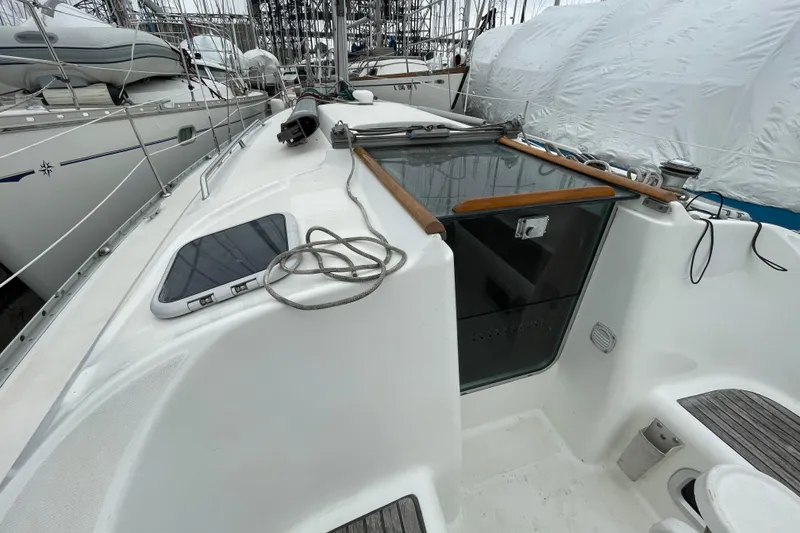 Slide: The Image of 2002 Beneteau 331 sailboat deck with hatch and rope, docked in marina. - 10