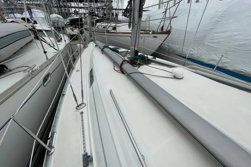 Slide: The Image of Cozy cabin interior of 2002 Beneteau 331 sailboat with wooden cabinetry and cushioned berth. - 25