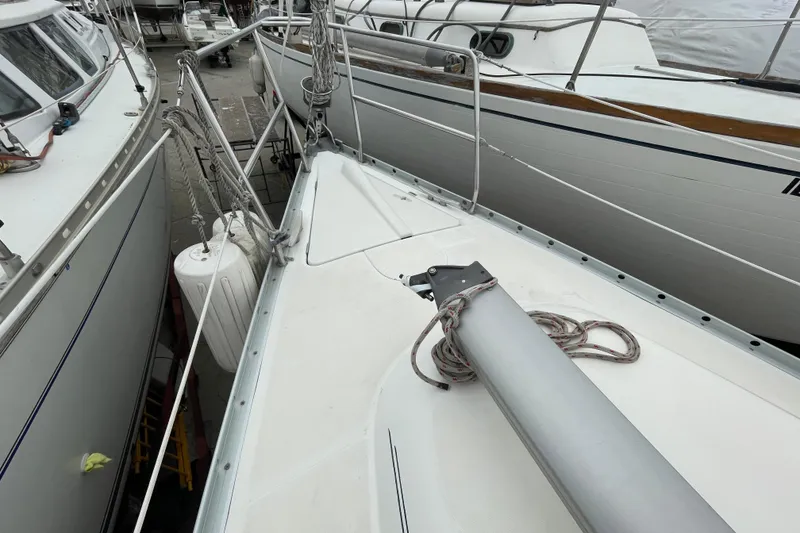 Slide: The Image of Interior cabin of 2002 Beneteau 331 sailboat, featuring wooden finish and blue patterned bedding. - 26