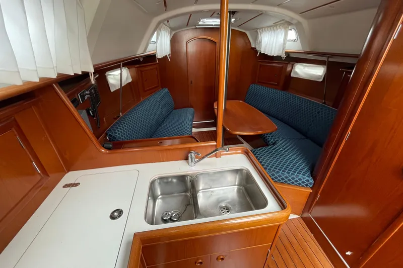 Slide: The Image of Interior of 2002 Beneteau 331 sailboat with wood finish and blue upholstery. - 29