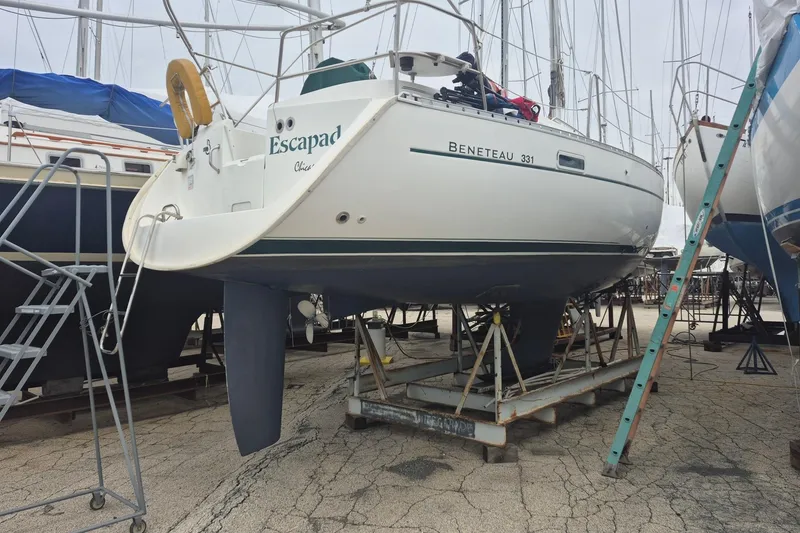 Slide: The Image of Sailboat Beneteau 331, 2002 model, named "Escapad," on dry dock for maintenance. - 4