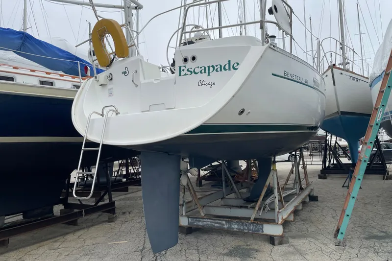 Slide: The Image of 2002 Beneteau 331 sailboat on dry dock, named "Escapade," with visible ladder and keel. - 5