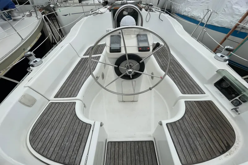 Slide: The Image of Cockpit of 2002 Beneteau 331 sailboat with wooden seating and steering wheel. - 7