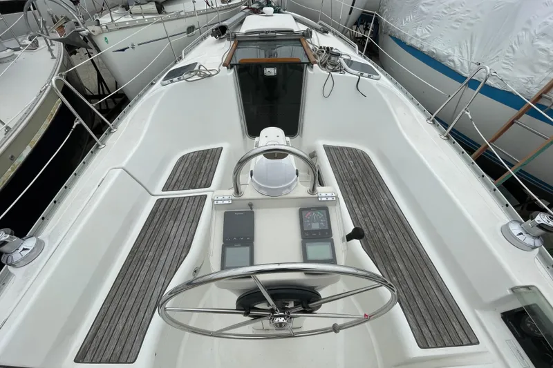 Slide: The Image of Cockpit of a 2002 Beneteau 331 sailboat with steering wheel and navigation instruments. - 9