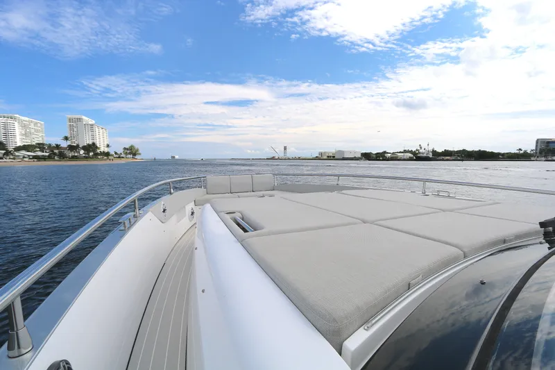 Slide: The Image of 2023 Azimut Verve 47 yacht cruising near a coastal city skyline under a blue sky. - 12