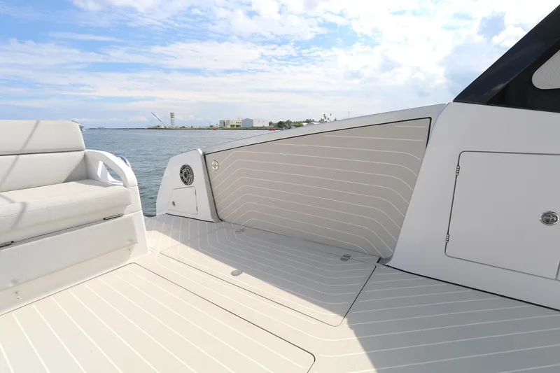 Slide: The Image of 2023 Azimut Verve 47 yacht deck with seating, overlooking calm waters and distant shoreline. - 17