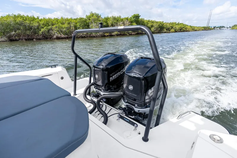 Slide: The Image of 2022 Axopar 37 XC Cross Cabin with dual Mercury outboard engines cruising on a scenic waterway. - 12