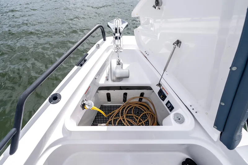 Slide: The Image of Anchor storage compartment on 2022 Axopar 37 XC Cross Cabin boat, featuring coiled rope and anchor. - 14