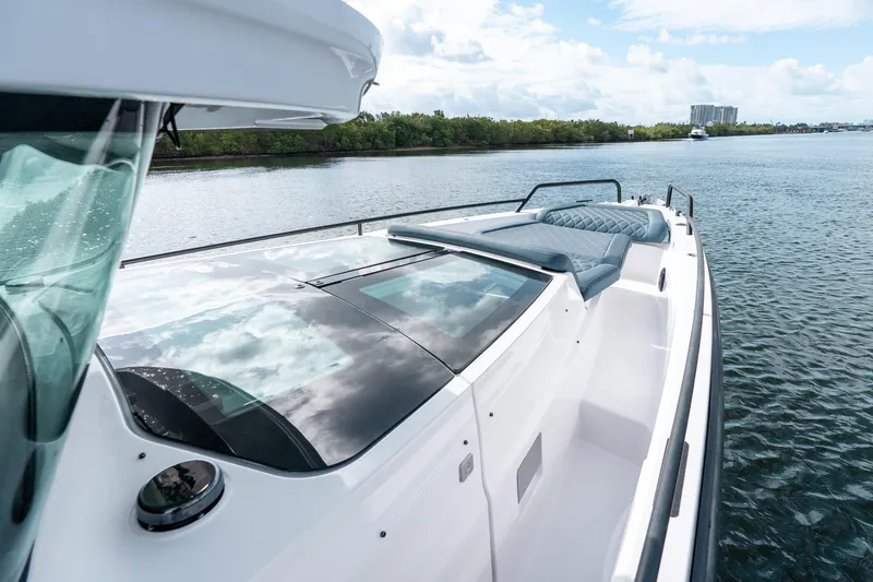 Slide: The Image of 2022 Axopar 37 XC Cross Cabin boat on calm water, featuring sleek design and spacious deck. - 19
