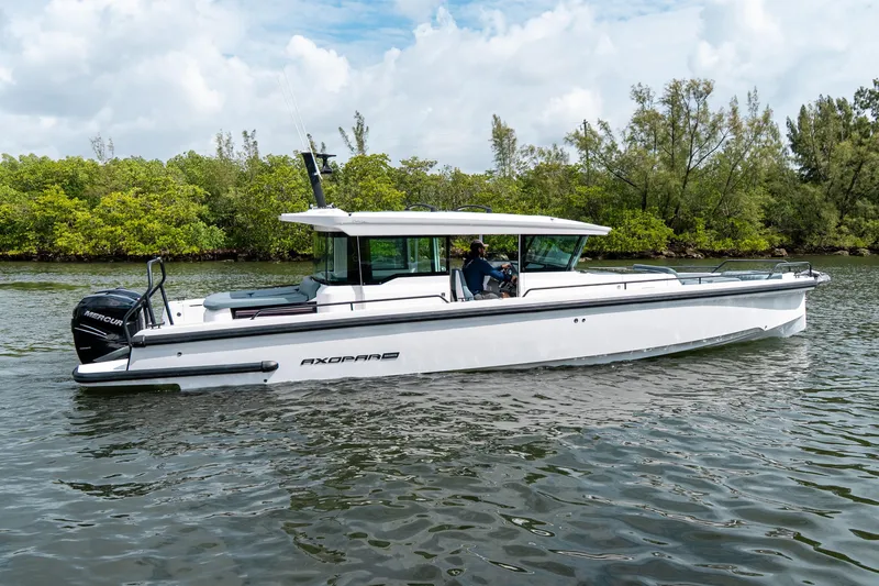Slide: The Image of 2022 Axopar 37 XC Cross Cabin boat cruising on a calm river. - 2