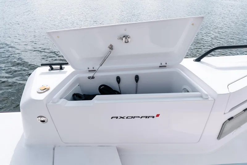 Slide: The Image of Open storage compartment on 2022 Axopar 37 XC Cross Cabin boat, near water. - 21