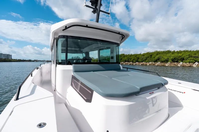 Slide: The Image of 2022 Axopar 37 XC Cross Cabin boat on a sunny day, cruising near lush shoreline. - 23