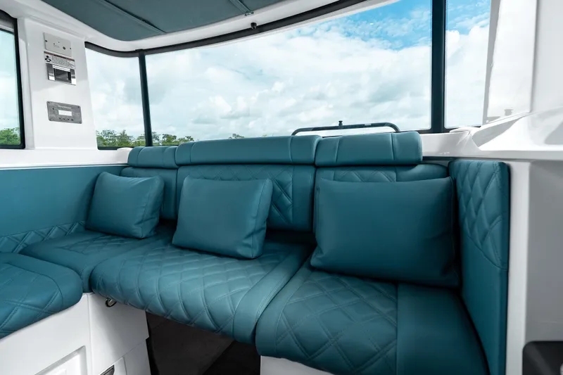Slide: The Image of Luxurious interior seating of 2022 Axopar 37 XC Cross Cabin with blue cushions. - 27