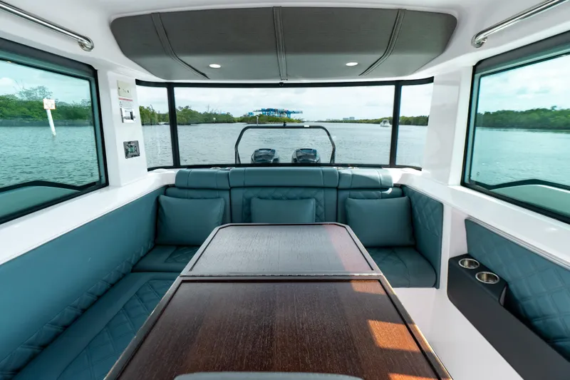 Slide: The Image of Interior of 2022 Axopar 37 XC Cross Cabin with seating and table, overlooking water. - 28