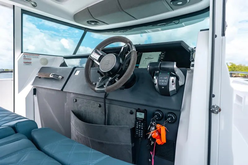 Slide: The Image of Interior view of 2022 Axopar 37 XC Cross Cabin helm with modern controls and steering wheel. - 35