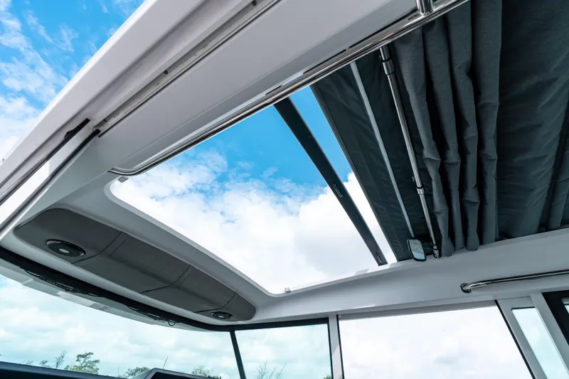 Slide: The Image of Sunroof view of 2022 Axopar 37 XC Cross Cabin against blue sky. - 36