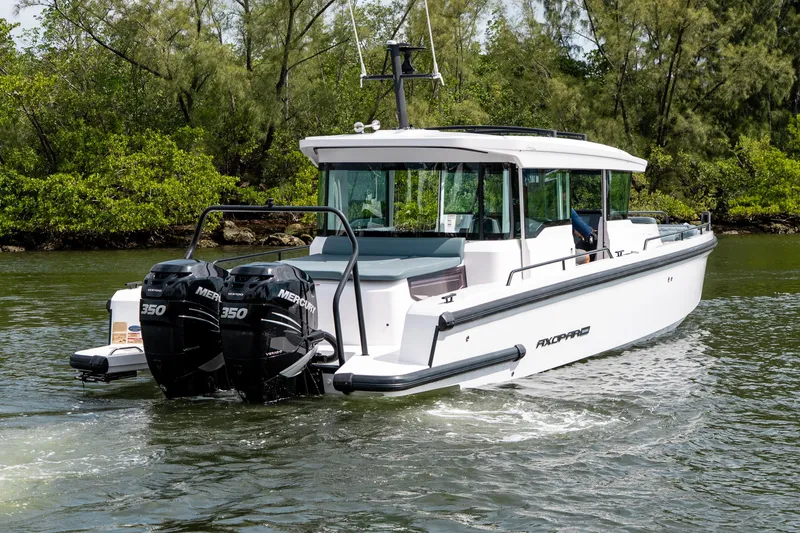 Slide: The Image of 2022 Axopar 37 XC Cross Cabin boat cruising on a scenic waterway. - 4