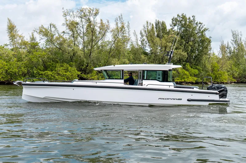 Slide: The Image of 2022 Axopar 37 XC Cross Cabin boat cruising on a scenic waterway. - 7